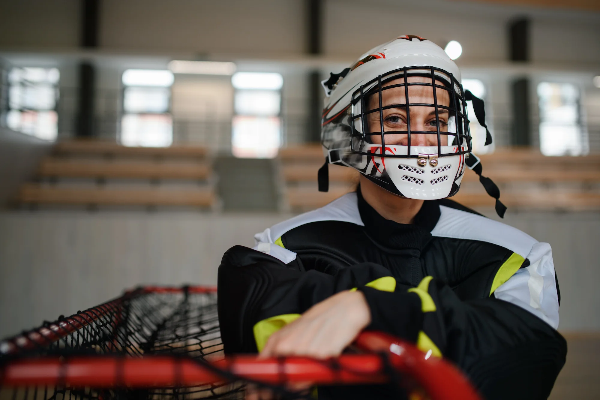A woman wearing a Lacrosse helmet looking into the camera